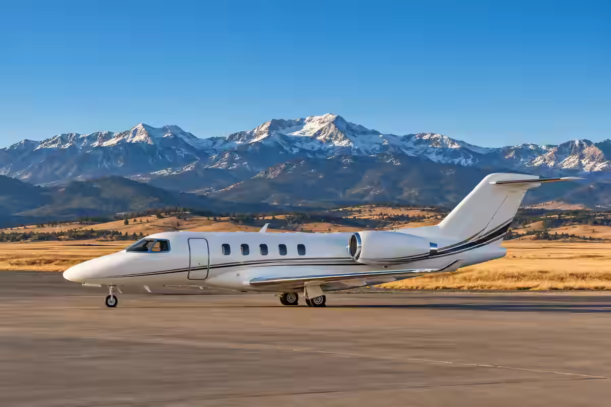 Destination-inspired illustration of a private jet beneath Colorado's snow-dusted Front Range