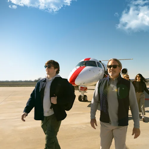 Passengers walking across the apron in front of a JSX jet